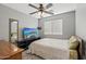 Bedroom with dark ceiling fan, TV on dresser and neutral wall color, window, and carpeted floor at 15453 W Shangri La Rd, Surprise, AZ 85379