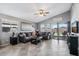 Bright living room with neutral walls, tile floors, sliding doors to patio, and comfortable sofas and modern ceiling fan at 15453 W Shangri La Rd, Surprise, AZ 85379