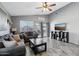 Cozy living room with tile floors, a ceiling fan, large windows, and sliding glass doors to the patio at 15453 W Shangri La Rd, Surprise, AZ 85379
