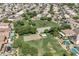 Expansive aerial view of a community park offering a basketball and sand volleyball court, lush green spaces, and walking trails at 15470 W Mauna Loa Ln, Surprise, AZ 85379