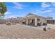 Large backyard featuring a covered patio, desert landscaping, and ample space for outdoor activities at 15470 W Mauna Loa Ln, Surprise, AZ 85379