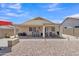 A spacious backyard boasts a covered patio with a built-in bar, seating area, and low-maintenance landscaping at 15470 W Mauna Loa Ln, Surprise, AZ 85379