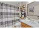 Bathroom with striped shower curtain, floating shelves, and modern sink and vanity at 15470 W Mauna Loa Ln, Surprise, AZ 85379