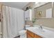 Bright bathroom with a shower/tub combo, decorative mirror, and storage cabinet at 15470 W Mauna Loa Ln, Surprise, AZ 85379