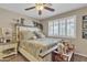 Bedroom with a decorative headboard, ceiling fan, and plantation shutters that fill the room with gentle light at 15470 W Mauna Loa Ln, Surprise, AZ 85379