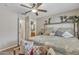 Cozy bedroom featuring a decorative bed, ceiling fan and an ensuite bathroom at 15470 W Mauna Loa Ln, Surprise, AZ 85379
