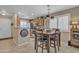 Open dining area and kitchen featuring pendant lighting and views to living area at 15470 W Mauna Loa Ln, Surprise, AZ 85379