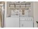 Well-equipped laundry room with a washer, dryer, storage shelves, and accessories at 15470 W Mauna Loa Ln, Surprise, AZ 85379