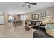 Open-concept living room with tile floors, a ceiling fan and seamless transition to the dining and kitchen area at 15470 W Mauna Loa Ln, Surprise, AZ 85379