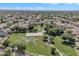 Aerial view of a neighborhood park, featuring a basketball court, green spaces, and walking paths at 15470 W Mauna Loa Ln, Surprise, AZ 85379