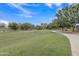 A tranquil neighborhood park features lush green grass and trees, inviting walking paths, and recreational space at 15470 W Mauna Loa Ln, Surprise, AZ 85379
