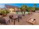 Inviting backyard with a pool, patio, fire pit, and cornhole game, ideal for outdoor entertaining at 16375 W Cortez St, Surprise, AZ 85388