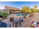 Resort-style backyard with a sparkling pool, lush palm trees, and ample seating for outdoor entertainment at 16375 W Cortez St, Surprise, AZ 85388