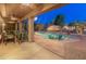 Expansive backyard featuring a pool, tiki umbrella, misting system, and covered patio for comfortable outdoor living at 16375 W Cortez St, Surprise, AZ 85388