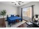 This bedroom features a black iron bed, a stylish gaming chair, and a sunny window with a neighborhood view at 16375 W Cortez St, Surprise, AZ 85388