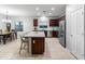 Open-concept kitchen with granite countertops, stainless steel appliances, and a large island with barstool seating at 16375 W Cortez St, Surprise, AZ 85388