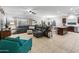 Open-concept living room with a leather sectional, tile flooring, and a view of the kitchen and dining area at 16375 W Cortez St, Surprise, AZ 85388