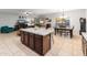 Open concept living room with an island, dining area, and backyard access at 16375 W Cortez St, Surprise, AZ 85388