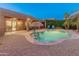 Stunning backyard featuring a sparkling pool, covered patio, and lush landscaping, perfect for relaxation and entertainment at 16375 W Cortez St, Surprise, AZ 85388