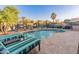 Beautiful pool with lounge chairs, palm trees and beach umbrella create a private tropical oasis at 16375 W Cortez St, Surprise, AZ 85388