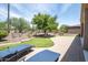 Well-maintained backyard with artificial turf, mature trees, and a spacious patio, ideal for outdoor enjoyment at 16772 W Cypress St, Goodyear, AZ 85395