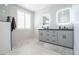 Modern bathroom with double vanity, neutral stone floors, and walk-in shower at 16772 W Cypress St, Goodyear, AZ 85395
