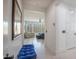 Bright bedroom view from hallway showing tiled floor, large windows, and upholstered chair at 16772 W Cypress St, Goodyear, AZ 85395