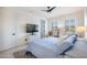 Bright bedroom with a lounge chair, TV, and access to the ensuite bathroom at 16772 W Cypress St, Goodyear, AZ 85395
