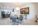 Open dining area featuring a chandelier, glass table, and an open layout to the kitchen at 16772 W Cypress St, Goodyear, AZ 85395