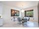 Elegant dining room featuring a modern chandelier, glass table, and views of the outdoor scenery at 16772 W Cypress St, Goodyear, AZ 85395