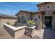 Cozy front patio with stone accents, two chairs, and potted plants for relaxed outdoor living at 16772 W Cypress St, Goodyear, AZ 85395