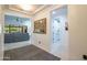 Inviting hallway leading to the living room, showcasing tray ceilings, an art piece, and access to laundry at 16772 W Cypress St, Goodyear, AZ 85395