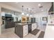 Kitchen island with white cabinets and marbled countertop offers a view to living room and dining area at 16772 W Cypress St, Goodyear, AZ 85395
