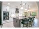 Modern kitchen with white cabinets, black hardware, and an island with bar seating at 16772 W Cypress St, Goodyear, AZ 85395
