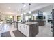 Open-concept kitchen with an island, white cabinets, stainless appliances, and gray accents at 16772 W Cypress St, Goodyear, AZ 85395