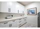 Well-lit laundry room features white cabinets, sleek hardware, and stylish decor for an organized space at 16772 W Cypress St, Goodyear, AZ 85395