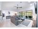 Bright, open concept living room with modern furniture, flowing into the kitchen and outdoor patio at 16772 W Cypress St, Goodyear, AZ 85395