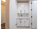 Bright mudroom featuring white cabinetry with black hardware, offering ample storage for organization and style at 16772 W Cypress St, Goodyear, AZ 85395