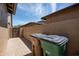 A view of the side yard featuring trash and recycling containers at 16772 W Cypress St, Goodyear, AZ 85395