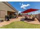 Desert landscaped backyard featuring an outdoor kitchen, patio seating and an expansive patio umbrella at 1680 E Cardinal Dr, Casa Grande, AZ 85122