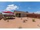 Landscaped desert backyard with shaded patio furniture and a well-manicured exterior at 1680 E Cardinal Dr, Casa Grande, AZ 85122