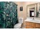 Functional bathroom with a floral shower curtain and a single-sink vanity with wood cabinetry at 1680 E Cardinal Dr, Casa Grande, AZ 85122