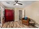 Cozy bedroom with wood floors, a red cabinet, and a comfortable reading chair at 1680 E Cardinal Dr, Casa Grande, AZ 85122