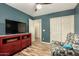 Comfortable bedroom with neutral wood floors, a red cabinet, and a relaxing armchair at 1680 E Cardinal Dr, Casa Grande, AZ 85122