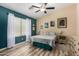 Comfortable bedroom with wood-look flooring, neutral walls, accent wall, ceiling fan, and lots of natural light at 1680 E Cardinal Dr, Casa Grande, AZ 85122