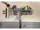 Clean and organized laundry room equipped with a washer and dryer set and shelving at 1680 E Cardinal Dr, Casa Grande, AZ 85122