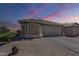 Single-story home with desert landscape, tile roof, two-car garage and bay window feature at sunset at 1769 E Jacob St, San Tan Valley, AZ 85140