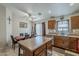 Open-concept kitchen and dining area with wood cabinets, stainless steel appliances, and island seating at 1769 E Jacob St, San Tan Valley, AZ 85140