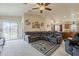Comfortable living room with a sectional sofa, ceiling fan, and sliding glass doors leading to the backyard at 1769 E Jacob St, San Tan Valley, AZ 85140