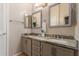 Bathroom featuring double sinks with granite countertop, three mirrors, and neutral color palette at 205 N 74Th St # 166, Mesa, AZ 85207